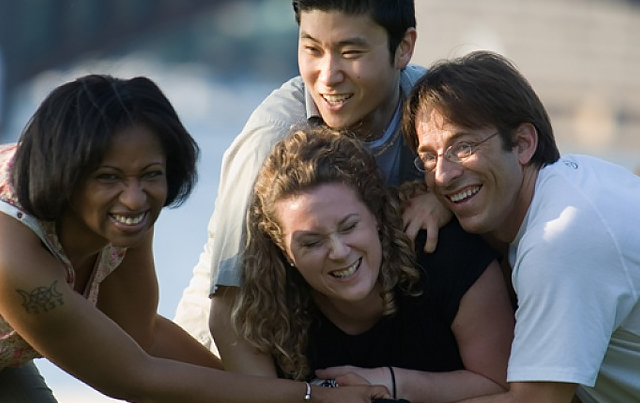 Four smiling people in huddle